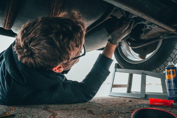 a mechanic fixing the underside of a car 